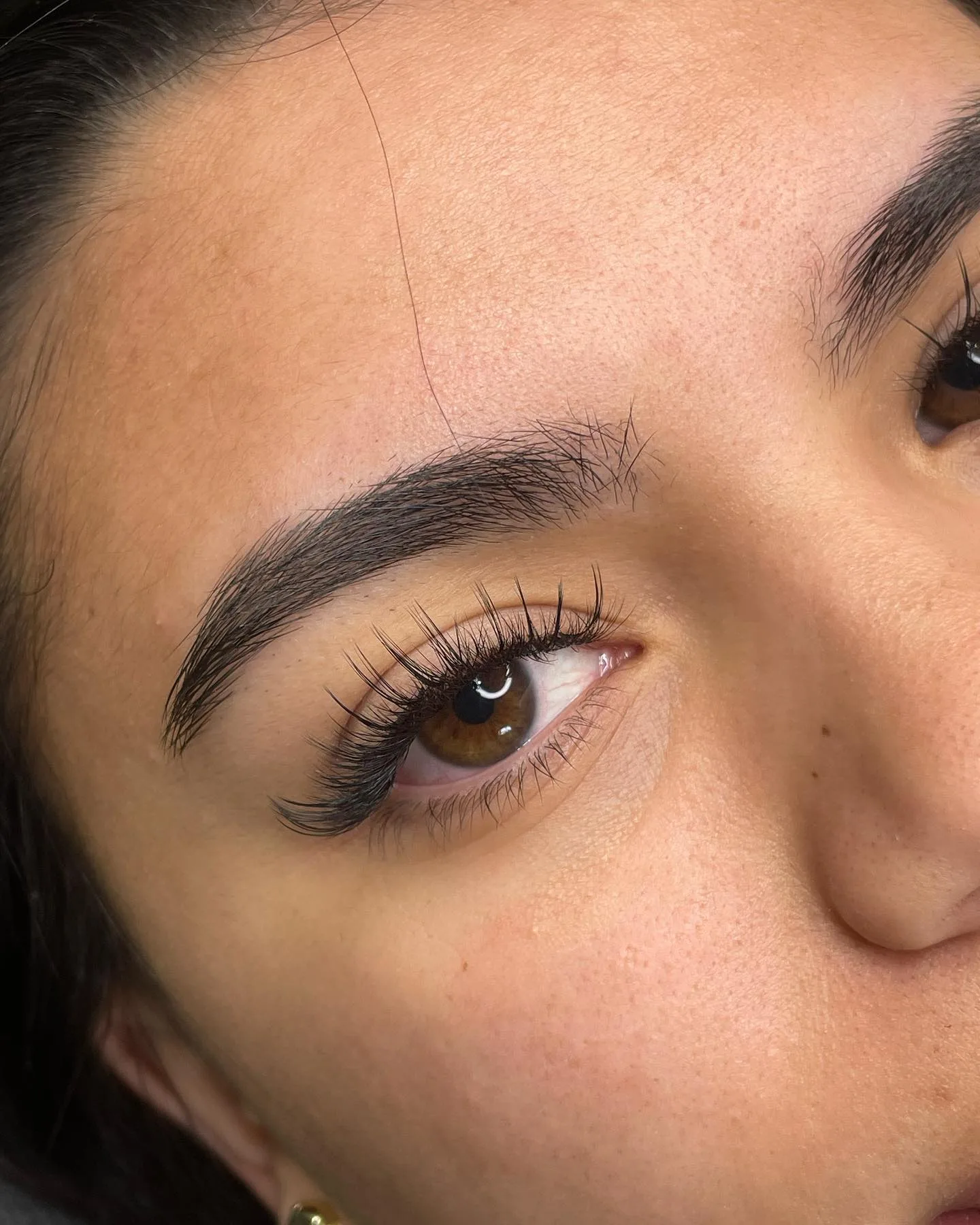 Natural wispy lash extensions with full groomed brow
