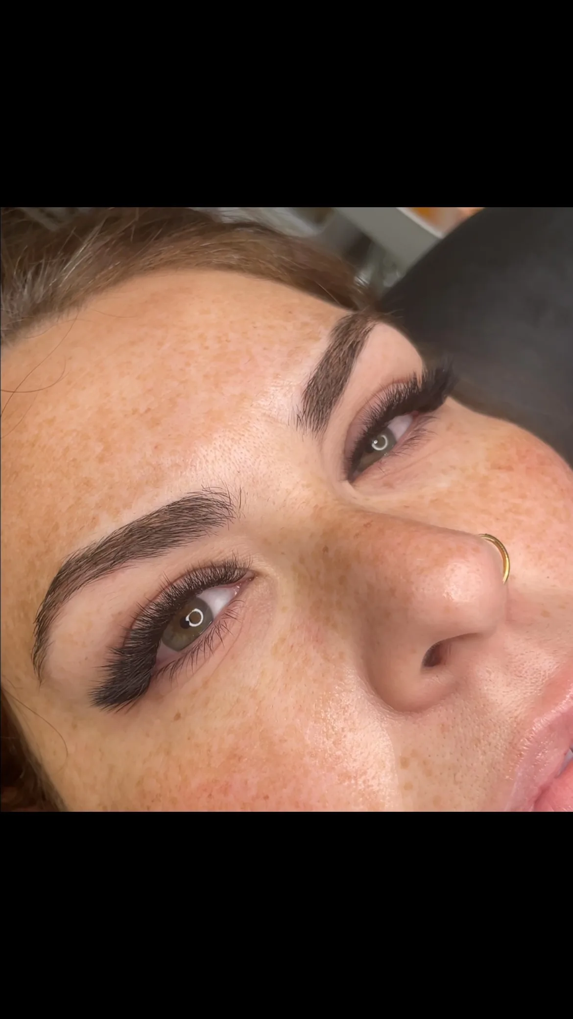 Volume lash extensions with laminated brows — freckled face, gold nose ring